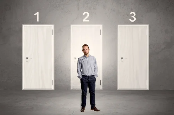 Businessman thinking in front of three doors — Stock Photo, Image