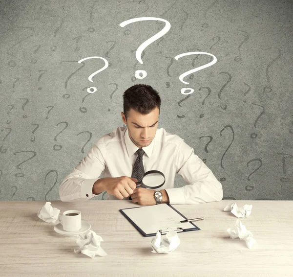 İş adamı soru işaretiyle masada.