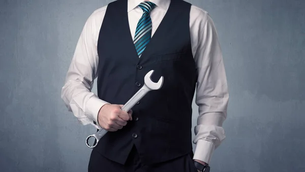 Бизнесмен стоит с инструментом на руке — стоковое фото