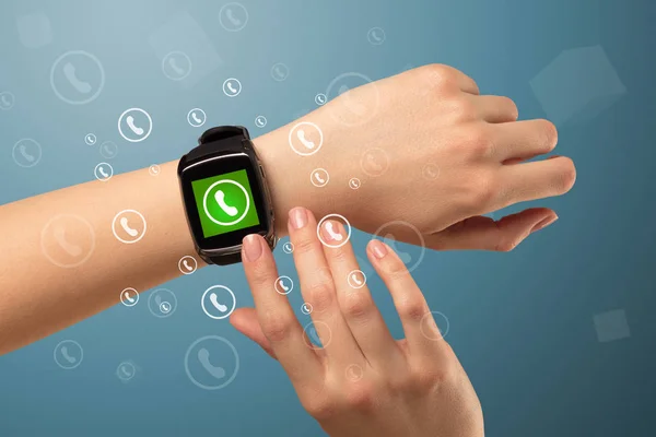 Main avec smartwatch et icône d'appel autour — Photo