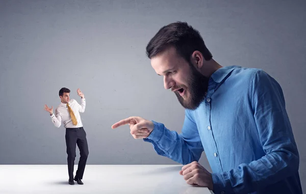 Young businessman fighting with miniature businessman — Stock Photo, Image