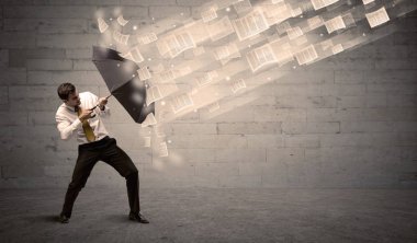 İş adamı ile şemsiye kağıtları rüzgara karşı koruma