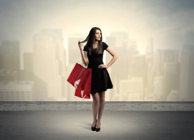 Alışveriş torbalarıyla duran şehir kadını.