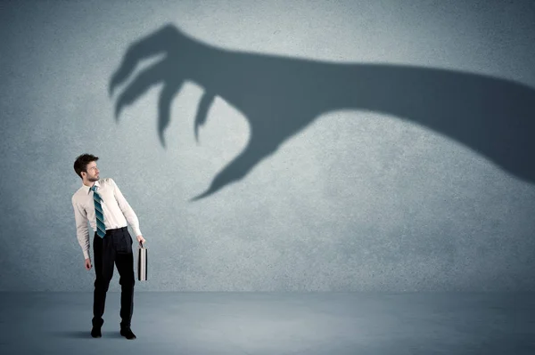 Persona de negocios con miedo de un gran concepto de sombra de garra monstruo —  Fotos de Stock