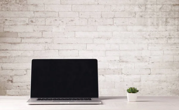 Business-Laptop mit weißer Ziegelwand — Stockfoto