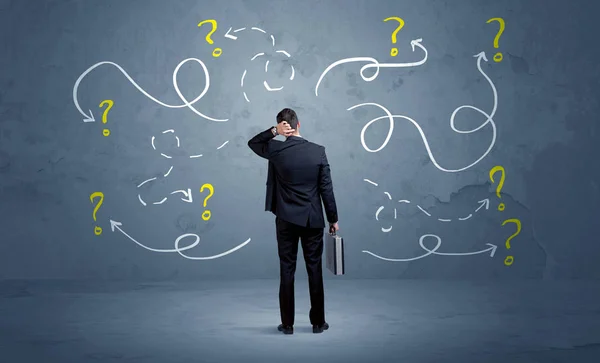 Unsure businessman with question marks — Stock Photo, Image
