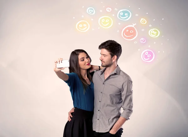 Happy couple taking selfie with smiley — Stock Photo, Image