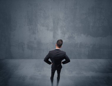 Şehir duvarının önünde duran iş adamı