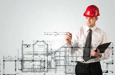 Genç bir mimar ev planı çiziyor.