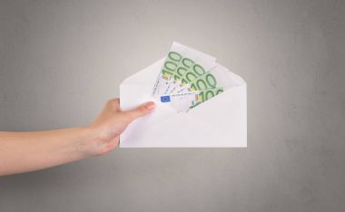 Zarf boş duvar arka plan ile tutan el