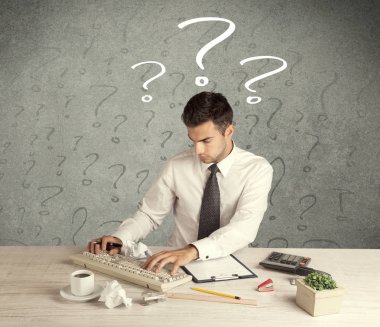 İş adamı soru işaretiyle masada.