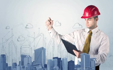 Genç işçi şehir manzarası çiziyor.