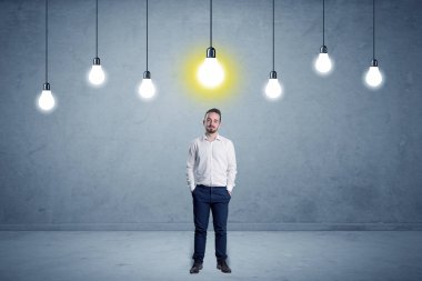 Businessman standing uninspired with bulbs above clipart