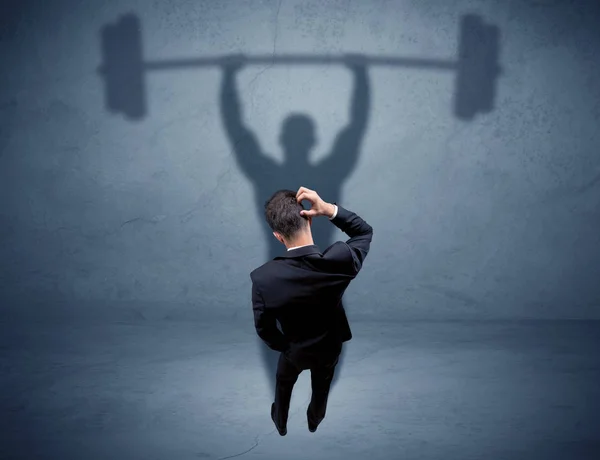 Businessman with weight lifting shadow — Stock Photo, Image