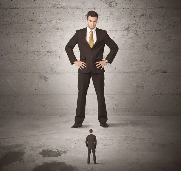 Büyük bir iş adamı küçük bir iş arkadaşına bakıyor.