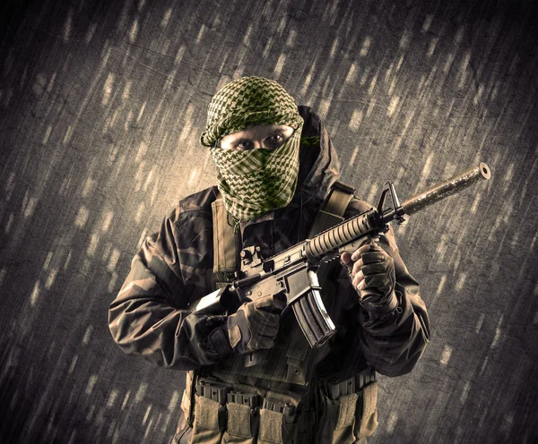 Yağmurlu arka plan üzerinde Maskeli silahlı terörist adam