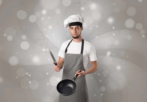 Мужчина повар с блестящими серыми обоями — стоковое фото