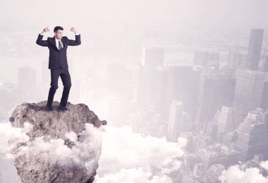 Kayanın üzerinde duran kazanan iş kişi