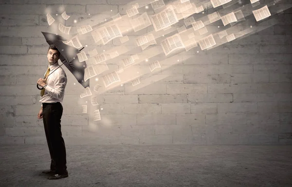 İş adamı ile şemsiye kağıtları rüzgara karşı koruma