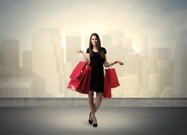 Alışveriş torbalarıyla duran şehir kadını.