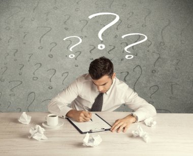 İş adamı soru işaretiyle masada.