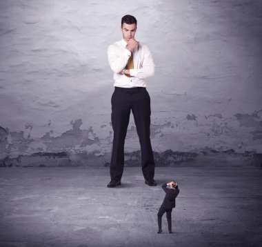 Kızgın büyük müdür küçük iş adamına bakıyor.