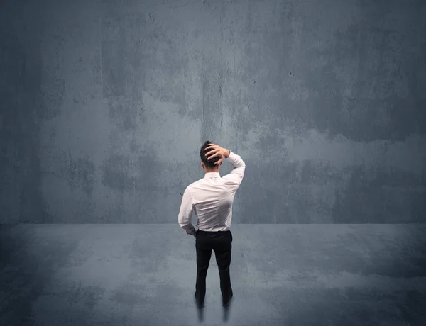 Businessman standing in front of urban wall — Stock Photo, Image