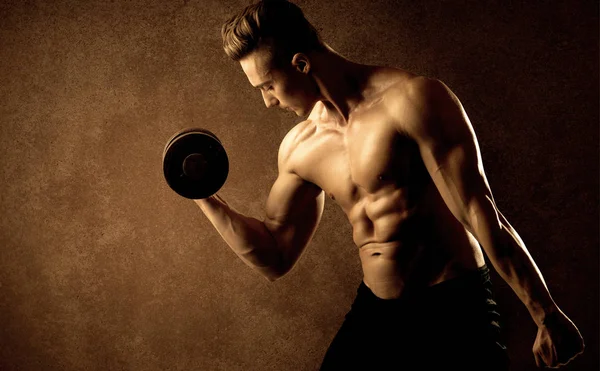 Kas formundaki vücut geliştirici sporcu ağırlık kaldırıyor 