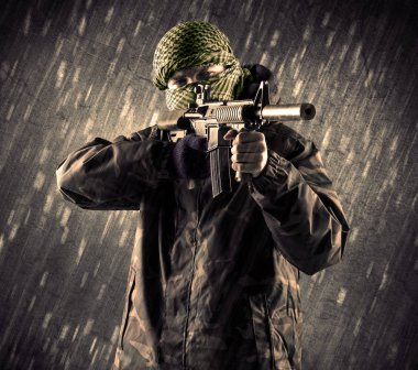 Yağmurlu arka plan üzerinde Maskeli silahlı terörist adam