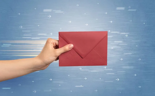 Hand holding envelope with arrows around — Stock Photo, Image