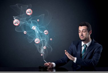 İş adamı sigara içiyor.