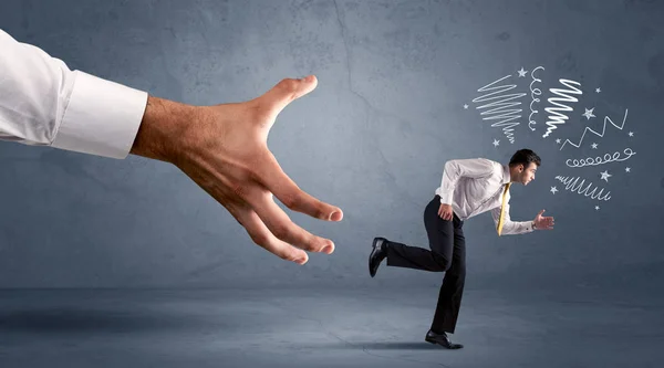 Stressful businessman running from a big hand — Stock Photo, Image