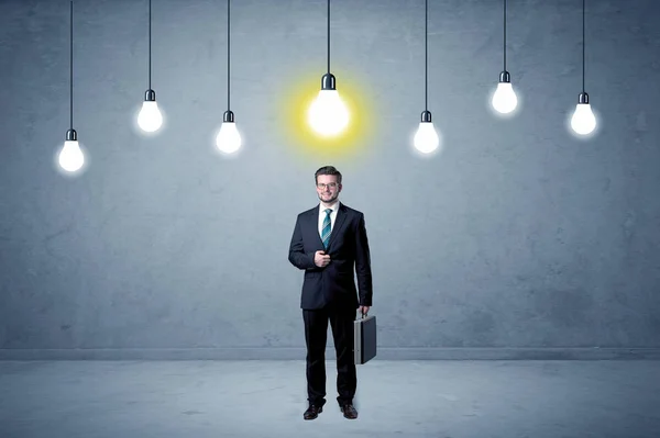 上記の電球と平凡な立っているビジネスマン — ストック写真