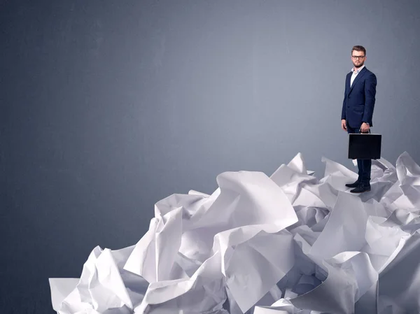 Businessman standing on crumpled paper — Stock Photo, Image
