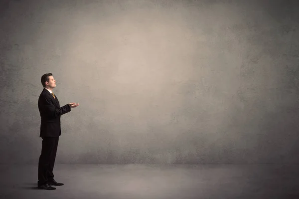 Businessman standing in front of a blank wall — Stock Photo, Image