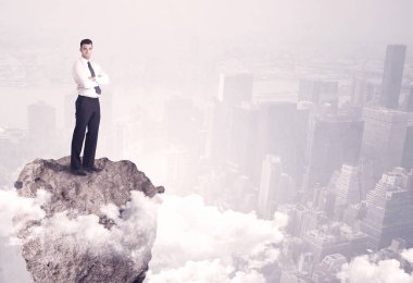 Kayanın üzerinde duran kazanan iş kişi