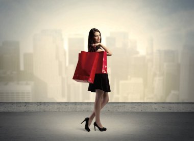 Alışveriş torbalarıyla duran şehir kadını.