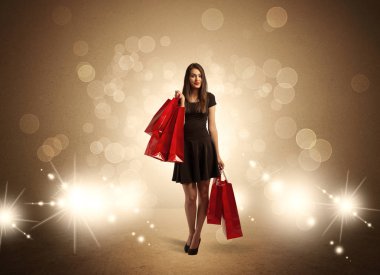 Parlak ışıklarda çantalı alışveriş yapan kadın.