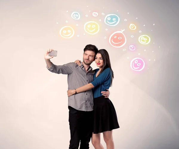 Happy couple taking selfie with smiley — Stock Photo, Image