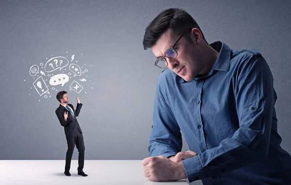 Young businessman fighting with miniature businessman — Stock Photo, Image