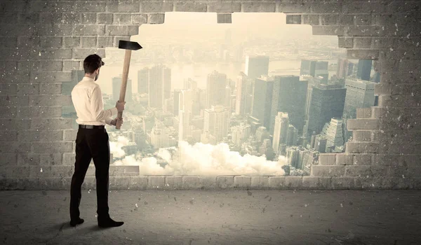 İş adamı şehir manzarasında çekiçle duvara çarpıyor — Stok fotoğraf