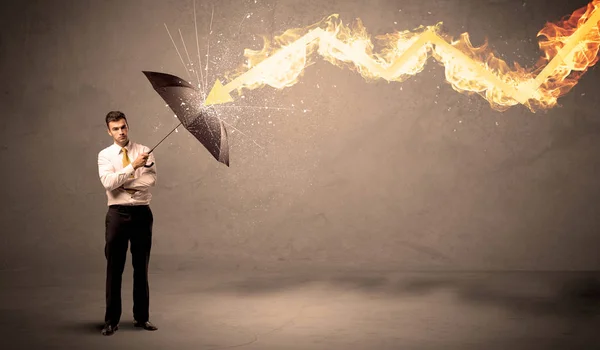 Homme d'affaires se défendant d'une flèche de feu avec un parapluie — Photo