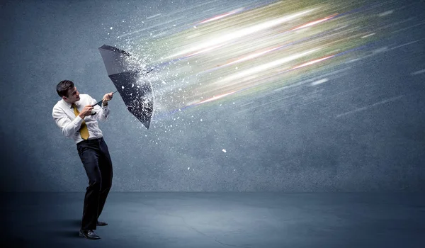 Business man defending light beams with umbrella concept — Stock Photo, Image