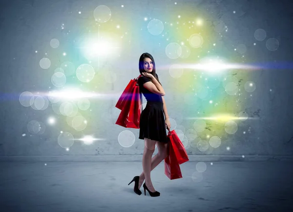ショッピングバッグや輝きの光を持つモールの女性 — ストック写真