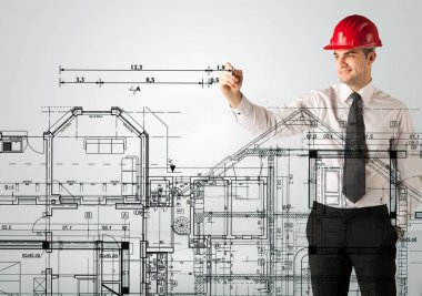 Genç bir mimar ev planı çiziyor.