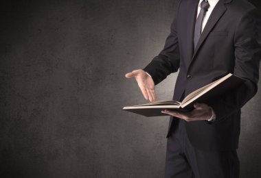 Elinde kitap tutan bir işadamı.