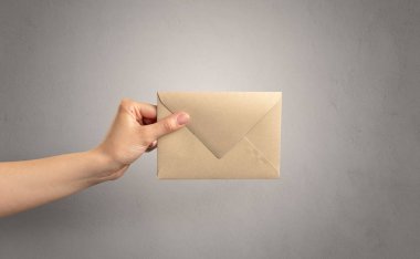 Zarf boş duvar arka plan ile tutan el