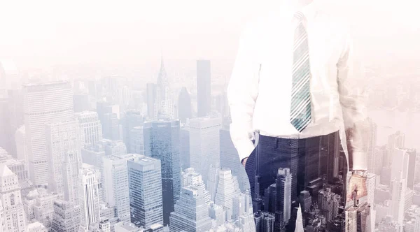 İş adamı çatıda duruyor ve arka planda şehir var.