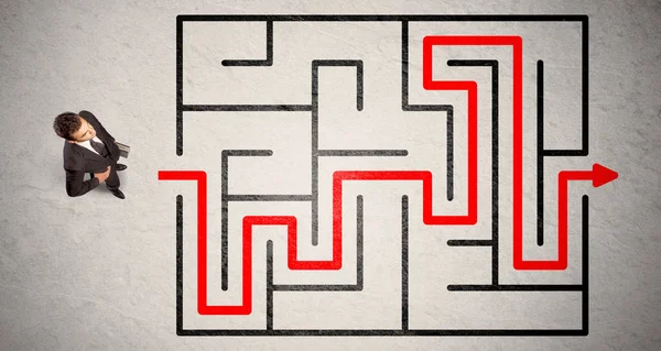 Uomo d'affari perduto trovato la strada nel labirinto con freccia rossa — Foto Stock