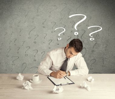 İş adamı soru işaretiyle masada.